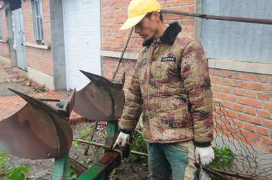 在哈尔滨市双城区东官镇东富村墙角处,锈迹斑斑的国产五铧翻转犁